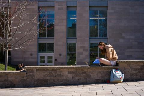 Student sitting in front of Hamilton Smith