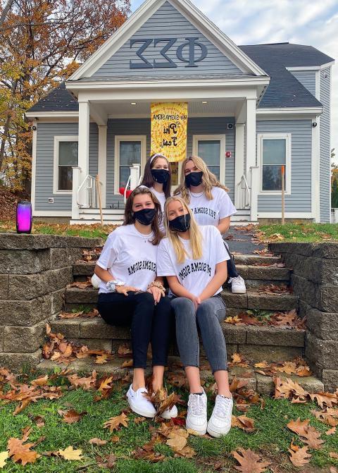 A group of women sitting on steps of home