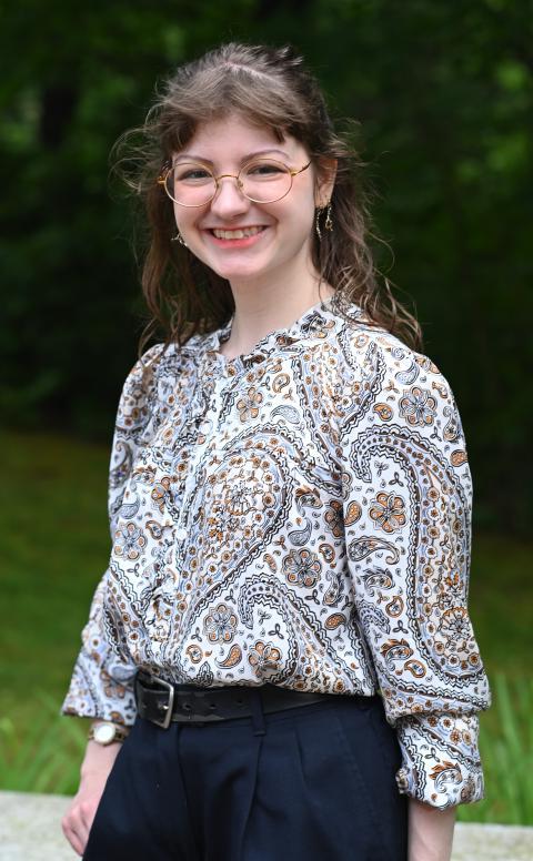 McNair scholar, professionally dressed, smiling, wooded backdrop