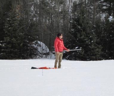 Tristan Amaral takes measurements of snow albedo.