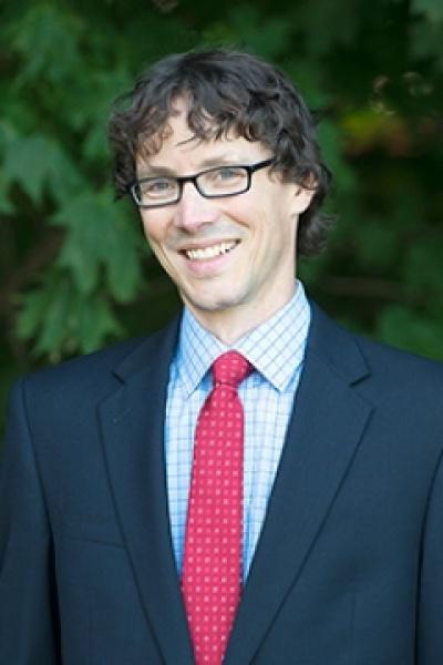 Portrait of 耶利米约翰逊, wearing glasses, suit jacket and red tie