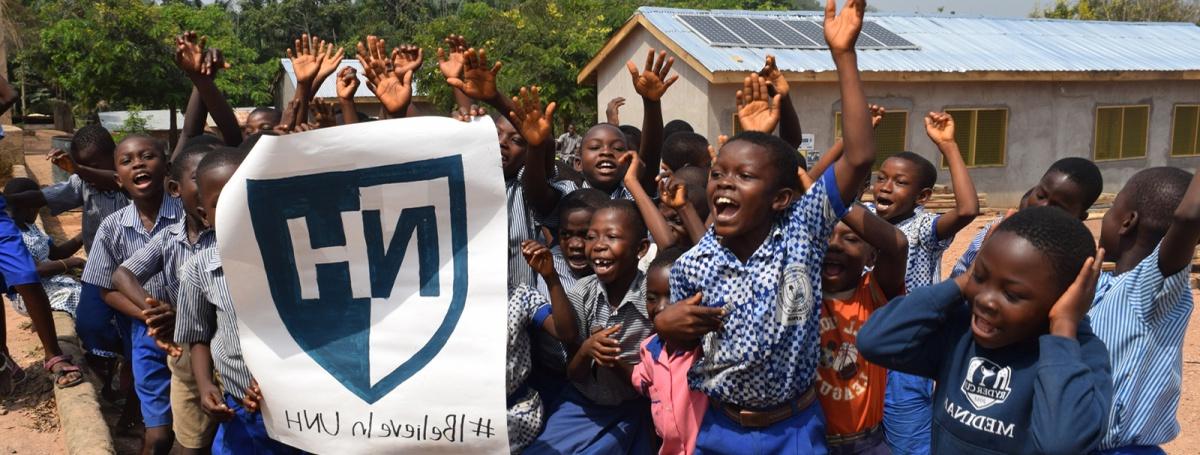 Schoolchildren hold a UNH banner in Ghana