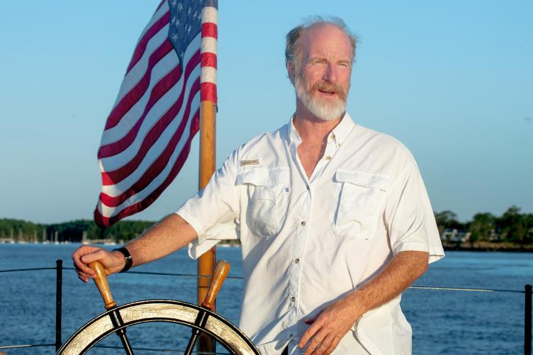 UNH professor of history Jeff Bolster driving a boat