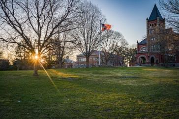 Thompson Hall at sunrise, with flag 