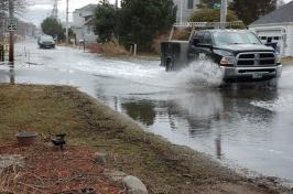 两辆车行驶在被洪水淹没的道路上.