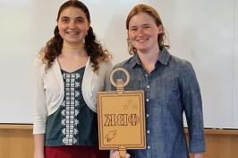 two students holding golden key