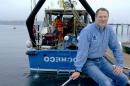 Larry Mayer sitting on a dock