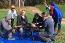 Group of researchers gathers around large drone outside on a sunny day.