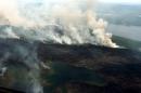 从山脉和湖泊上空的飞机上可以看到野火产生的浓烟. 