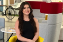 Cassaundra Kalba sits in a chair for a professional headshot.